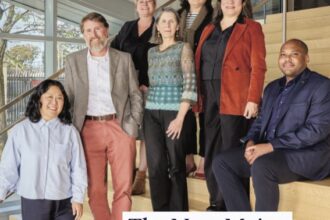 A mix of men and women from different ages to races stand on a stairwell as the issue covers the new major gifts officer